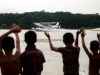 Crowds of children and adults gather to watch the float plane land in Bhola, Bangladesh.