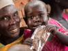 14 November 2016. Aweil: (Left to right) Abuk Kuot holds malnourished child Nyubol Kwatch (3), while eating Plumpy'Nut (a peanut-based paste) given at the feeding centre (outpatient therapeutic programming) run by Medair in Aweil, South Sudan
	Alarming levels of malnutrition and an upsurge in malaria numbers put thousands of lives at risks in Northern Bahr el Ghazal, South Sudan. A full-scale emergency response has been launched by the humanitarian community. Medair, an international emergency relief and recovery organisation, is part of this response and is providing emergency nutrition and health services, safe water, and sanitation and hygiene support
	The emergency levels of malnutrition are compounded by a malaria upsurge in the past weeks and the limited access to water and sanitation facilities. The limited availability of essential drugs and the small number of staff in health facilities have made it very difficult for people to receive adequate treatment in time unless they have enough money to pay. .Medairs emergency response team is providing critical services to the most vulnerable in the area. The team has set up three emergency nutrition clinics to treat children under five with acute malnutrition.
	Photo by Albert Gonzalez Farran - MEDAIR